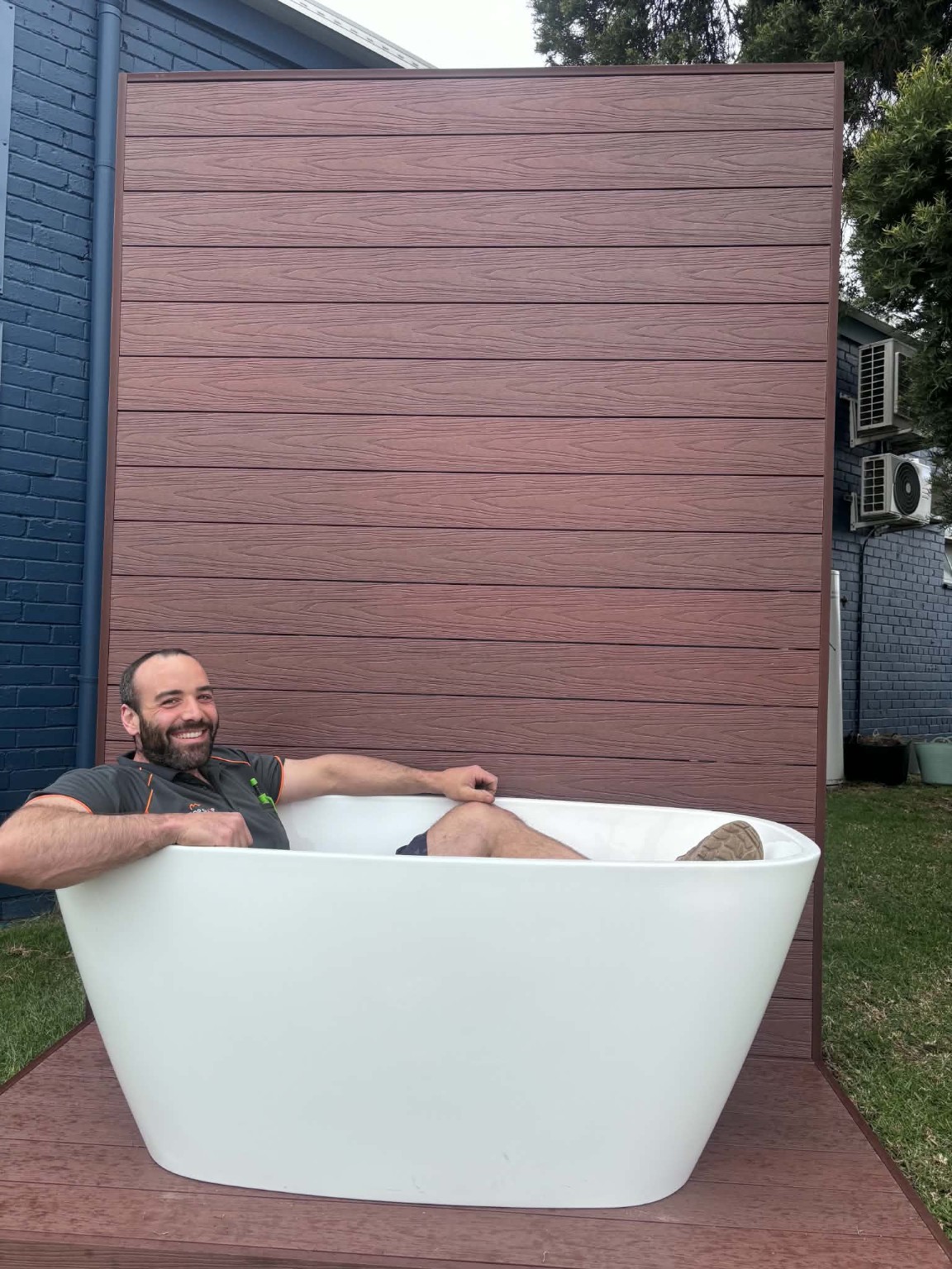 Alex smiling while sitting in a freestanding bathtub